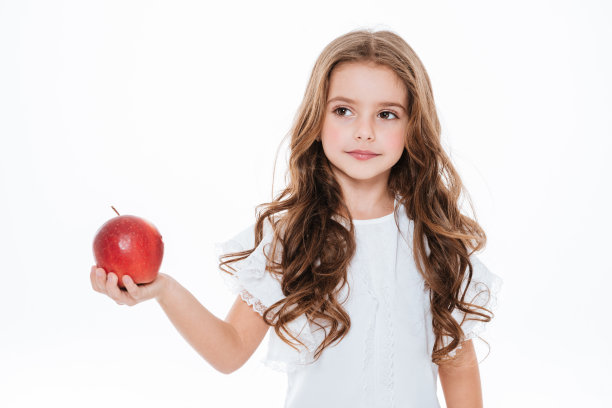 美丽的卷发小女孩拿着红苹果的肖像图片下载