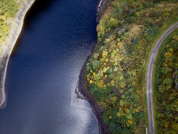 易北河的航拍照片，一条道路沿着河流本身的弯曲，在秋天的树木装饰图片下载