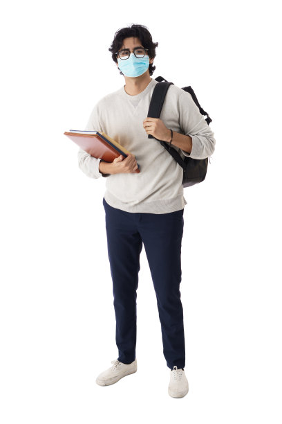 男学生戴着面具，拿着书看着摄像机图片下载