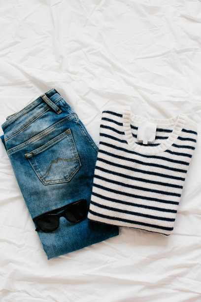 女性的时尚服装和饰品放在白色背景下，平放。条纹毛衣和蓝色牛仔裤。随意看。图片下载