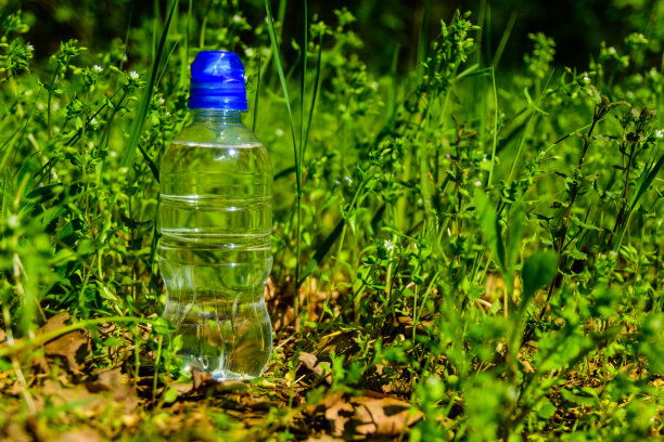 塑料瓶里装着绿草如茵的清水图片下载