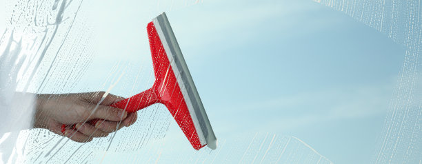 女人在春天的一天用橡皮擦擦窗户，近景。旗帜设计图片下载