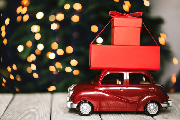 红色玩具古董车与圣诞礼物与节日灯的背景。文本。图片下载