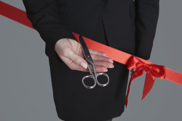 特写的女商人拿着剪刀在红丝带图片下载