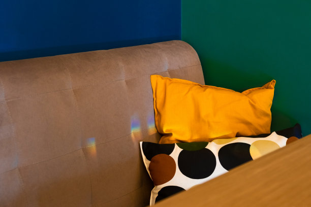 咖啡馆内部有蓝色和深绿色的墙壁和橙色的枕头。概念现代色块室内设计。餐厅室内设计选择。图片下载