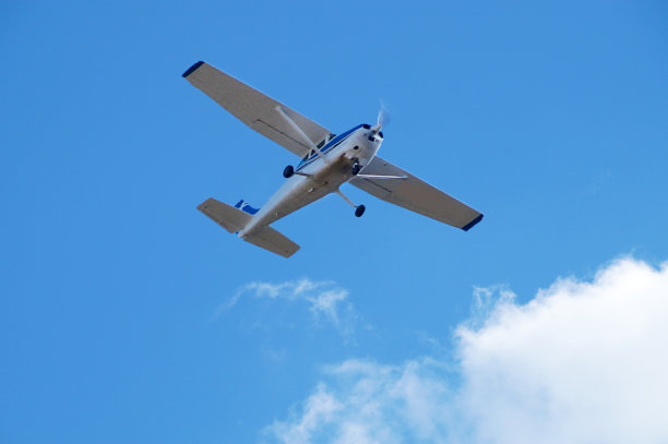 小单引擎飞机在晴朗的天空和白云的背景下，俯视特写图片下载