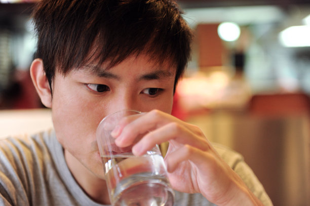 年轻人在喝一杯水。图片下载