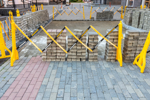 可折叠的塑料栅栏挡住了通道。修复行人专用区，更换铺路石图片下载