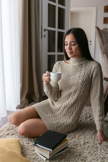 一个女人坐在窗边，端着一杯咖啡图片下载