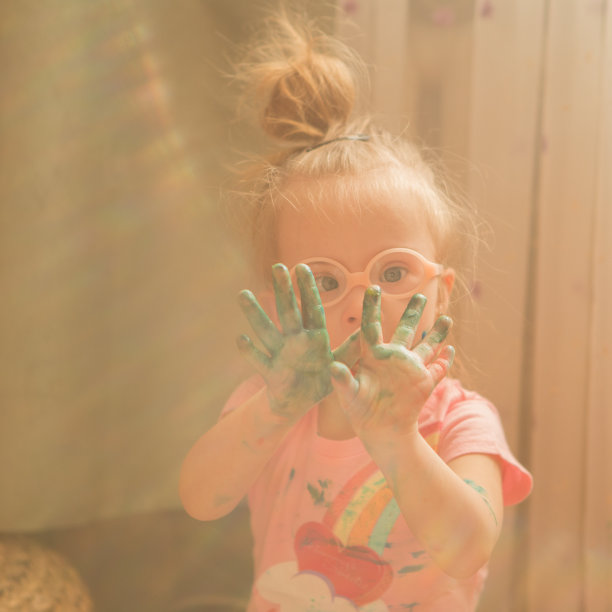 患有唐氏综合症的女孩在画画时被颜料覆盖图片下载