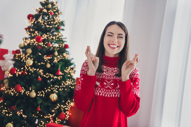 年轻开朗的女士的照片，交叉手指，梦想，期待等待圣诞礼物，庆祝节日在室内图片下载