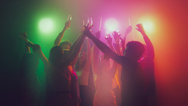 一群年轻，活跃的人们在夜总会，在霓虹灯下跳舞图片下载