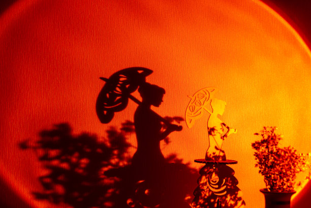 拿着伞的女人雕像在灯光照耀下的树枝上图片下载