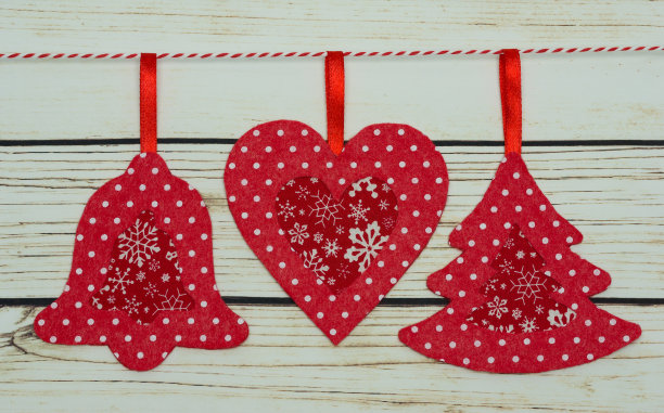 木制背景上手工制作的红色毡圣诞玩具图片下载