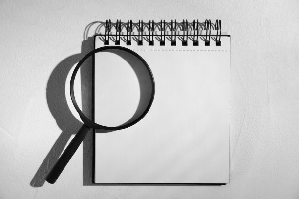 放大镜玻璃和空笔记本在浅色的石头背景，平铺与文本空间。找到关键字的概念图片下载