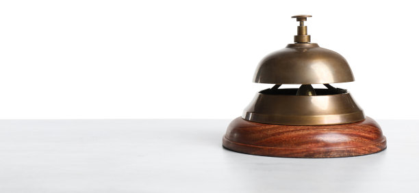 酒店的服务钟放在白色背景的木桌上图片下载