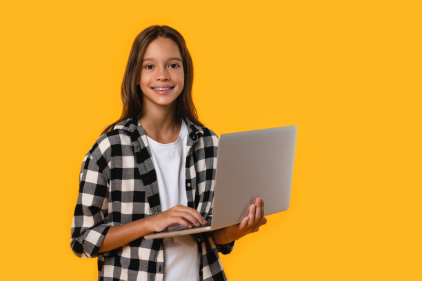 使用笔记本电脑的快乐白人少女，用于社交媒体发帖、在线学习、观看网络研讨会、网上银行，黄色背景图片下载