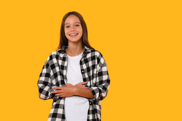 快乐的白人女学生在黄色背景中开怀大笑，心情愉快图片下载