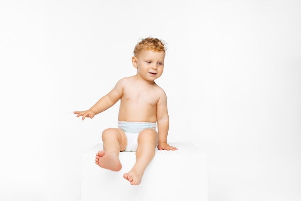 小男孩的全长肖像，孩子在尿布坐孤立的白色背景图片下载