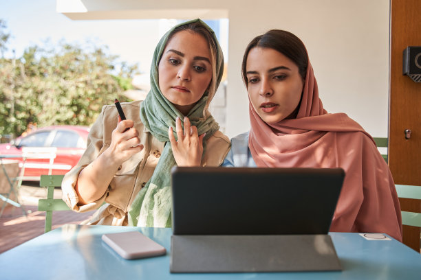 两个伊斯兰最好的朋友在平板电脑前看着如何和解图片下载