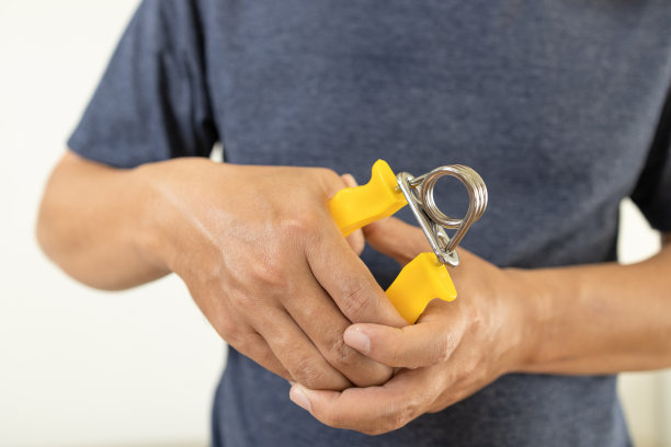 男患者的手是做手掌或手腕运动用弹簧手握力、挤压用手扩张器、伸展手指肌腱、治疗肌肉无力、帕金森病、理疗、保健图片下载
