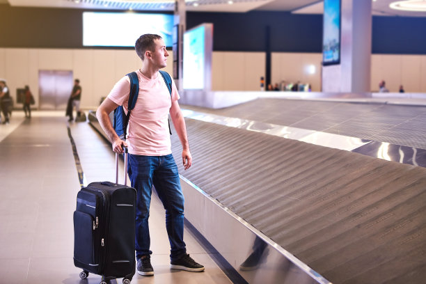 一名欧洲男性旅客(乘客)在伊斯坦布尔哈瓦利马尼国际机场(IST机场)到达(出发)时从行李领取带中领取行李。图片下载