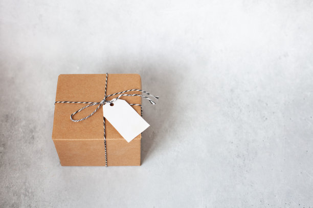 手工礼品盒与空标签和缠绕在灰色混凝土背景。图片下载