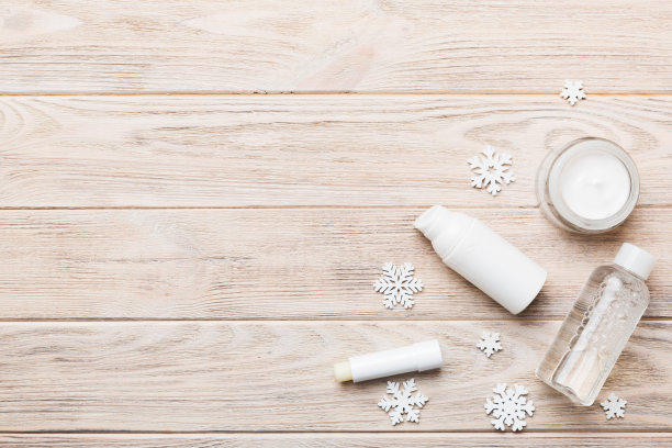 彩妆产品和圣诞装饰品的色彩背景。顶视图新年美容概念与复制空间图片下载