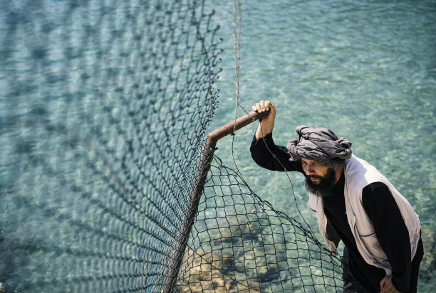 站在栅栏后的难民男子图片下载