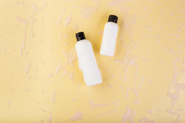 两个不同大小的塑料瓶在淡黄色上。没有标签。关闭，俯视图，复制空间的文本或徽标图片下载