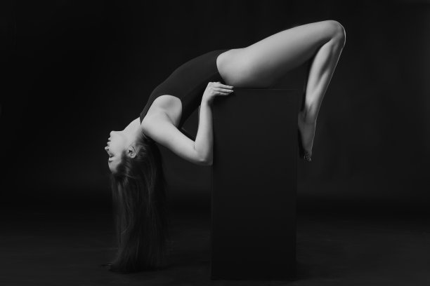 漂亮的深褐色女人在身体套装在立方体上黑色的背景。黑色和白色图片下载