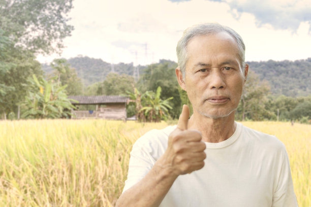 一位身穿白色t恤的老人举着“OK”的牌子图片下载