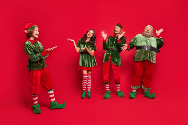 全身照片的快乐惊奇的圣诞老人助手戴上帽子圣诞节气氛举起手孤立在红色背景图片下载