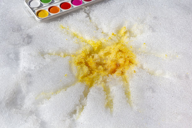 DIY和孩子的创造力。用颜料、水彩和画笔在雪地上画出黄色的太阳。教育的冬季奥运会。孩子的发展。有趣的家庭时间。图片下载