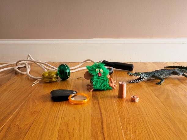 将玩具捡起，放在橡木地板上的儿童玩具包括魔方、溜溜球、拼字游戏和跳绳图片下载