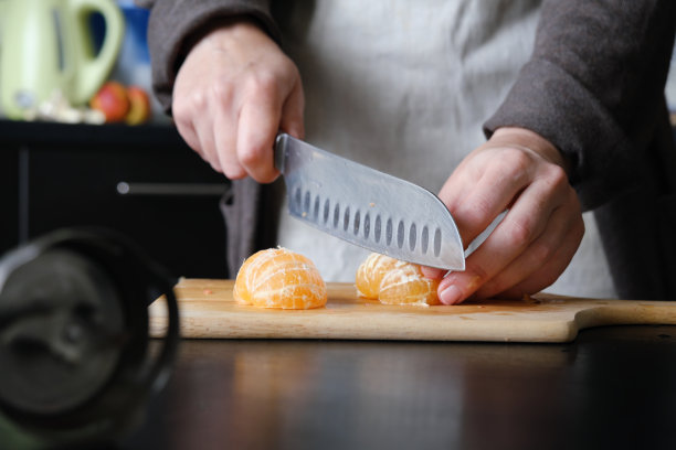 一个不知名的人正在切水果和蔬菜做辣酱图片下载