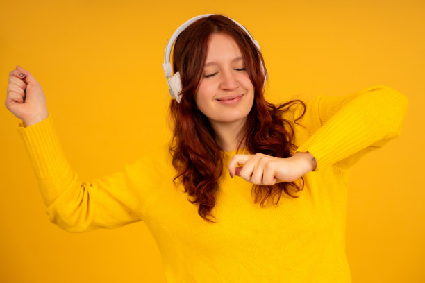 年轻女子戴着耳机听音乐。图片下载