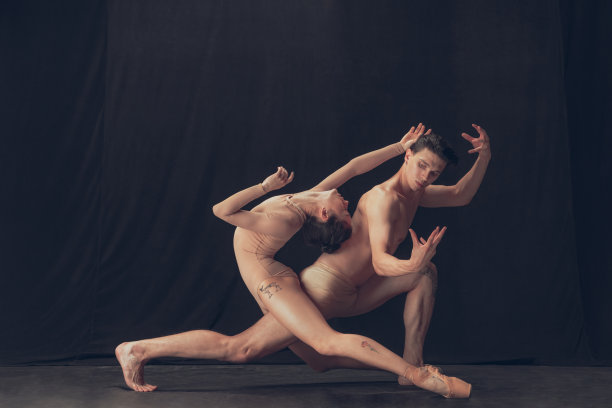 两个柔韧的舞者，年轻的男人和女人在现代艺术表演隔离在黑色的工作室背景。艺术，运动，灵感概念。图片下载