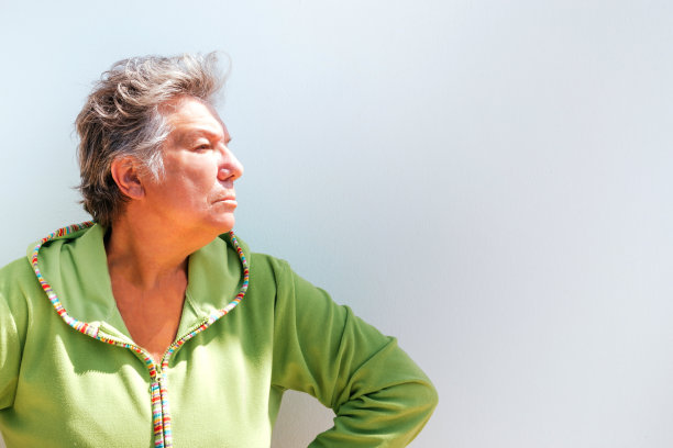 一名中年妇女的侧面肖像，灰白短发，在白色背景下看起来很生气。照片与copyspace图片下载