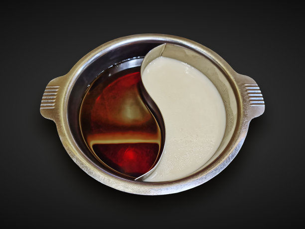 高角度的涮锅锅与两种汤类型孤立在黑色图片下载