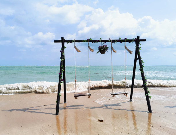 海滩上有装饰的木制秋千图片下载