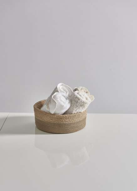柳条篮子和毯子，白色的桌子和墙壁图片下载