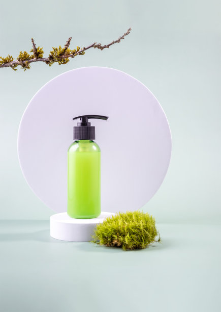 圆形讲台上放着化妆品的容器和长着苔藓的树枝图片下载