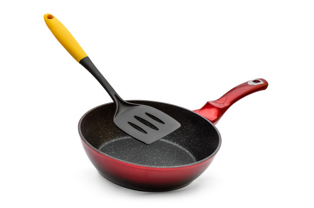 白色背景上有塑料铲的平底锅。图片下载