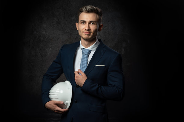 年轻的白人商人建筑师工程师，手里拿着白色的防护头盔。特写镜头，有一张聪明的脸。图片下载