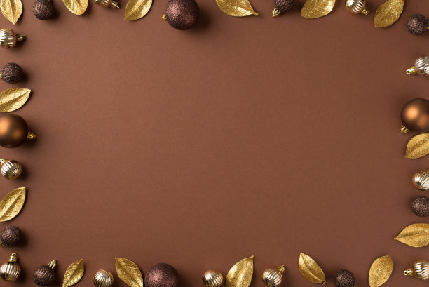 俯视图照片的圣诞树装饰金棕色的银球和金色的叶子孤立的棕色背景与中间的空白图片下载
