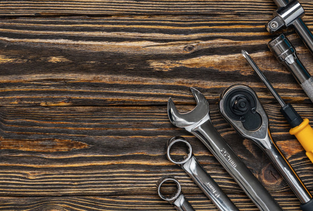 汽车修理工具和扳手在一个深棕色的木制背景。本空间图片下载