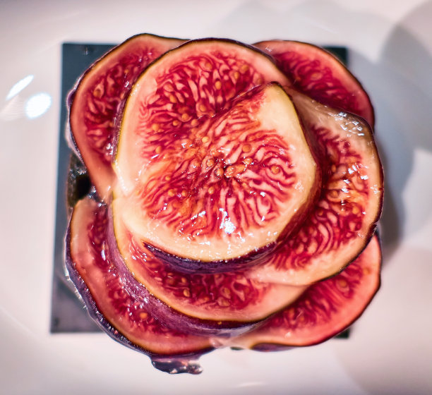甜红无花果片放在白色盘子上，收起来图片下载