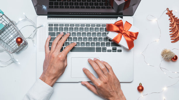 在线的圣诞节。礼品盒红丝带，购物车和笔记本电脑，钱在平铺网上购物构图。冬季圣诞假期销售。图片下载