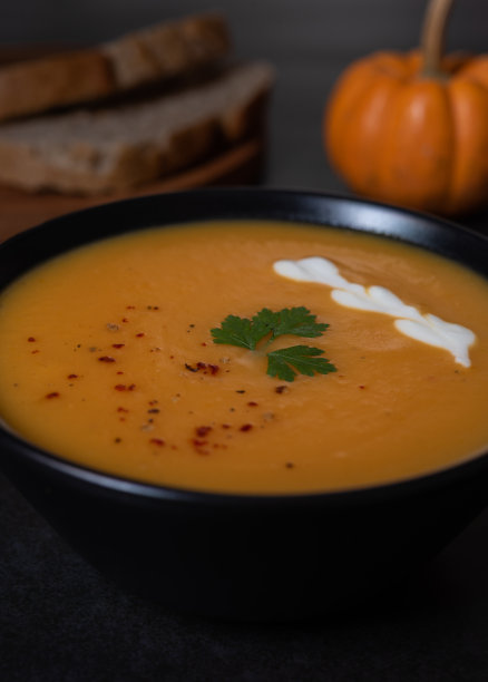 黑碗里的南瓜汤，还有酸奶。低调照片。图片下载